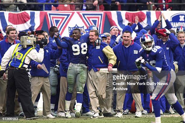 New York Giants' coach Jim Fassel and Jessie Armstead celebrate with teammates as the Giants crushed the Minnesota Vikings, 41-0, in the NFC...