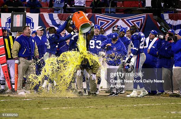 New York Giants' coach Jim Fassel disappears in a deluge of Gatorade, courtesy of his players after they swamped the Philadelphia Eagles, 20-10, in...