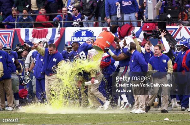 New York Giants' coach Jim Fassel gets a soft-drink bath in the fourth quarter as his team was busy crushing the Minnesota Vikings, 41-0, in the NFC...