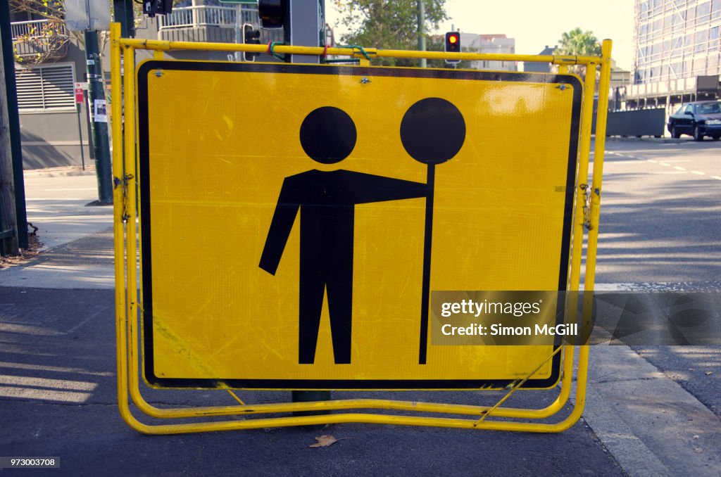Temporary 'Prepare to Stop' sign on the sidewalk of an inner city road