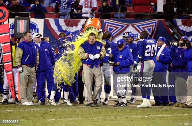 New York Giants' coach Jim Fassel is deluged with Gatorade, courtesy of his players after they swamped the Philadelphia Eagles, 20-10, in National...