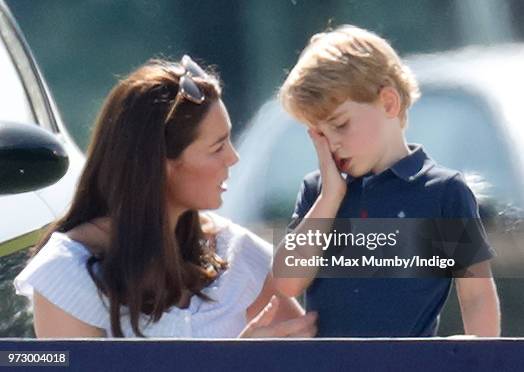 Catherine, Duchess of Cambridge comforts Prince George of Cambridge as they attend the Maserati Royal Charity Polo Trophy at the Beaufort Polo Club...