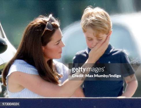 Catherine, Duchess of Cambridge comforts Prince George of Cambridge as they attend the Maserati Royal Charity Polo Trophy at the Beaufort Polo Club...