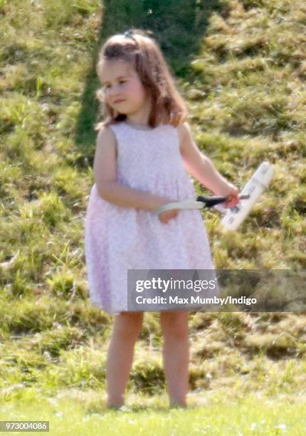 Princess Charlotte of Cambridge plays with a polo mallet as she attends the Maserati Royal Charity Polo Trophy at the Beaufort Polo Club on June 10,...