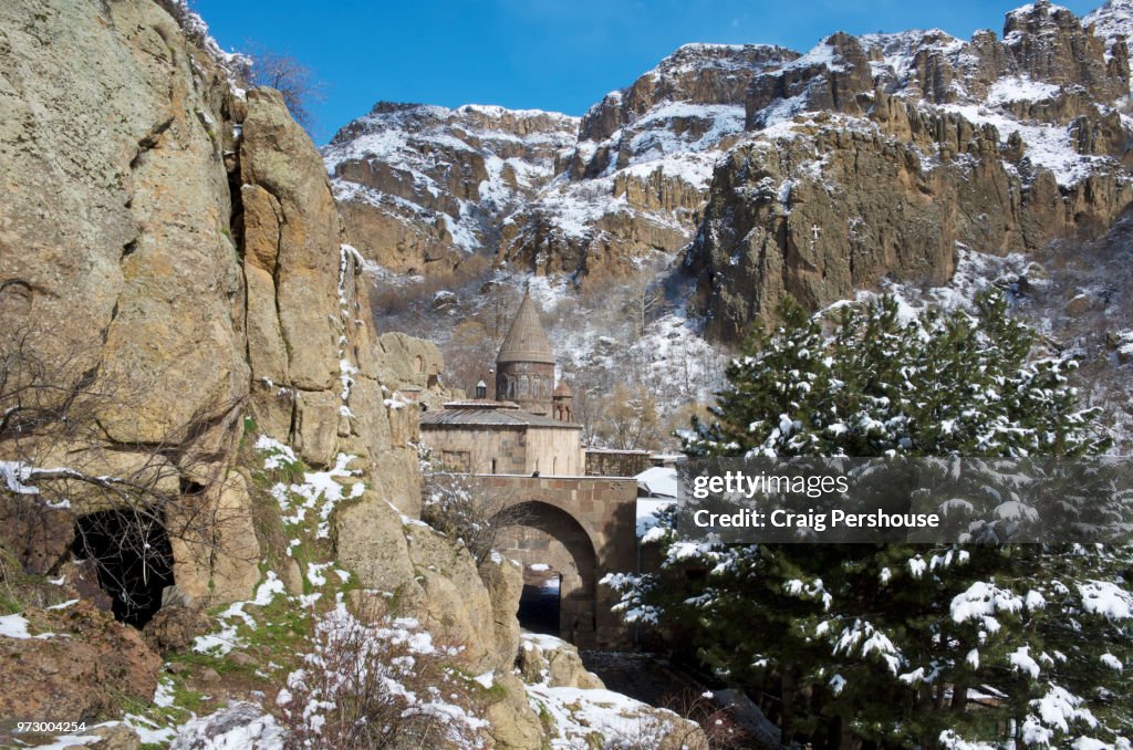 Surp Astvatsatsin Church (Holy Mother of God Church) and stone bridge in snow-covered canyon at Geghard Monastery.