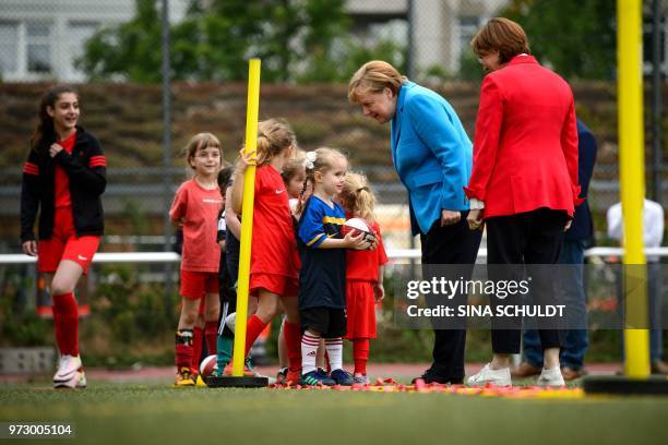 German Chancellor Angela Merkel talks with children as she takes part in the event "Sports and Integration" as she visits the "SV Rot-Weiß Viktoria...