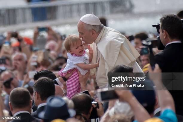 Pope Francis kisses a baby as he arrives to attend his weekly general audience, in St. Peter's Square, at the Vatican, Wednesday, June 13, 2018.