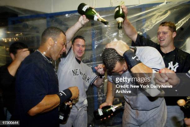 Champagne flows as New York Yankees' Gary Sheffield, John Flaherty, Alex Rodriguez and Jon Lieber celebrate in the locker room after winning Game 4...