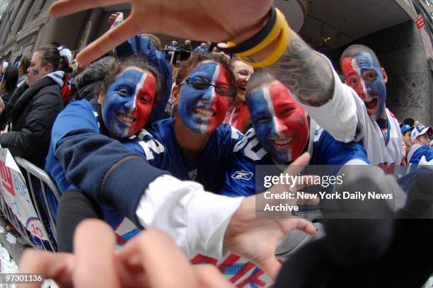 New York Giants fans Julia Shteynan, Tami Smoyto, Paula David and Anthony Bilfalco of Brooklyn show their spirit as they line Broadway during the...