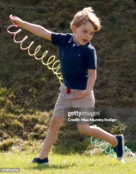 Prince George of Cambridge plays with a Slinky toy as he attends the Maserati Royal Charity Polo Trophy at the Beaufort Polo Club on June 10, 2018 in...