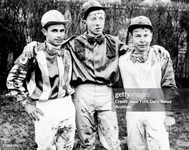 Jockeys Sebastian Perez, William Weingart and Hedley Woodhouse, whose mounts finished out of the money, are spattered with mud after the fifth race...