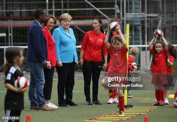 German Chancellor Angela Merkel looks on as young girls train during a program to encourage integration of children with foreign roots through...