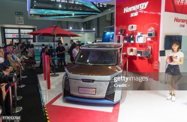 Showgirl presents a solar-powered electric car by Hanergy at the Consumer Electronics Show Asia in Shanghai on June 13, 2018. / China OUT