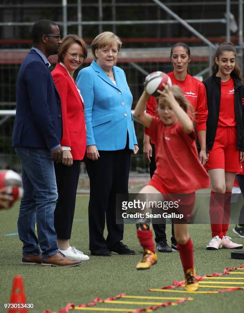 German Chancellor Angela Merkel looks on as young girls train during a program to encourage integration of children with foreign roots through...