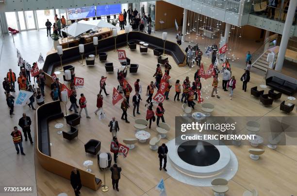 Protesters walk in the ADP headquarters during the visit of Economy Minister Bruno Le Maire near the Roissy Charles de Gaulle airport on June 13,...