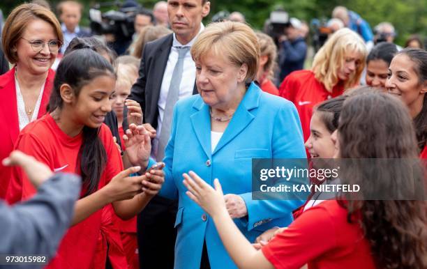 German Chancellor Angela Merkel speaks with girls taking part in the event "Sports and Integration" as she visits the "SV Rot-Weiß Viktoria Mitte 08"...