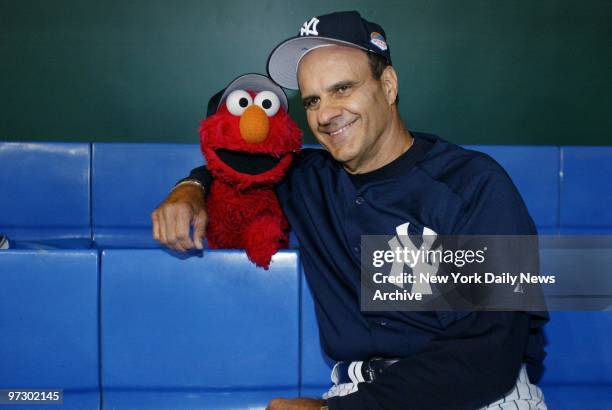 New York Yankees' manager Joe Torre puts his arm around Elmo, a character from the children's television show Sesame Street, before an exhibition...