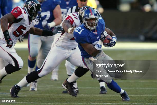 New York Giants' halfback Tiki Barber eludes a takler in the first half of game against the Atlanta Falcons at Giants Stadium. Barber fumbled twice...