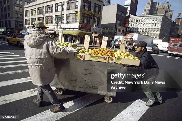 Fruit stand being pushed across Canal Street.