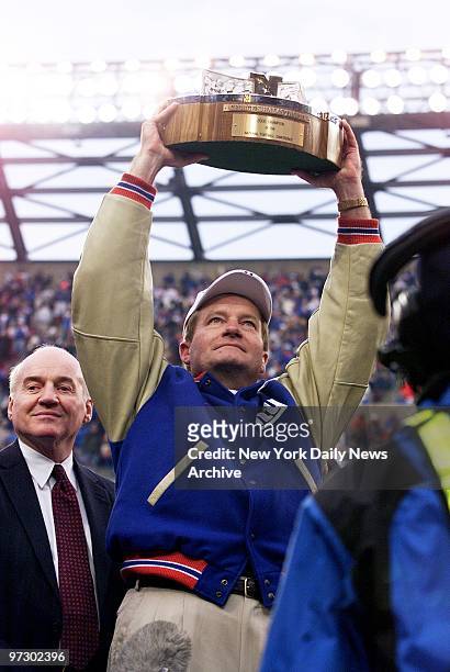 New York Giants' head coach Jim Fassel holds trophy high after his team crushed the Minnesota Vikings, 41-0, in the NFC Championship Game at Giants...