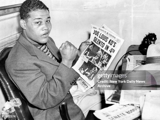 Joe Louis reads about his victory over Tony Galento in the Daily News.