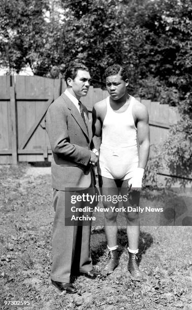 Joe Louis seems to be thinking of a dreadful night at the Yankee Stadium as he shakes the hand that once shook his chin aplenty. Max Schmeling...