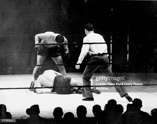 Joe Louis stands over his fallen foe, Max Schmeling, after battering him to the canvas.