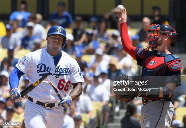 Yasiel Puig of the Los Angeles Dodgers breaks his bat in front of catcher Tyler Flowers of the Atlanta Braves after striking out in the third inning...