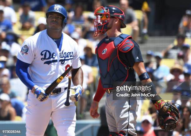 Yasiel Puig of the Los Angeles Dodgers breaks his bat in front of Tyler Flowers of the Atlanta Braves after striking out with the bases loaded in the...