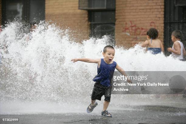 Joel Chavel plays in the water from an open fire hydrant on Tudor Place and The Grand Concourse in the Bronx during a hot & humid Wednesday afternoon.