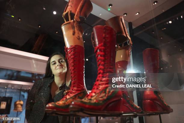 Museum employee poses in front of lace-up boots, 1953-4, Mexico on display during an exhibition entitled 'Frida Kahlo: Making Her Self Up' at the...