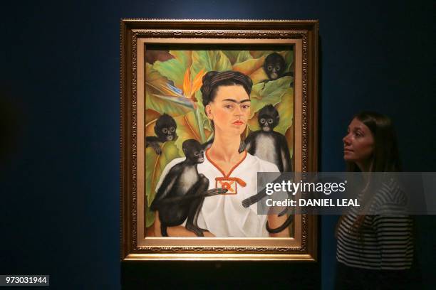 Museum employee poses in front of an artwork entitled Self-portrait with Monkeys, Frida Kahlo Coyoacan, Mexico, during an exhibition entitled 'Frida...