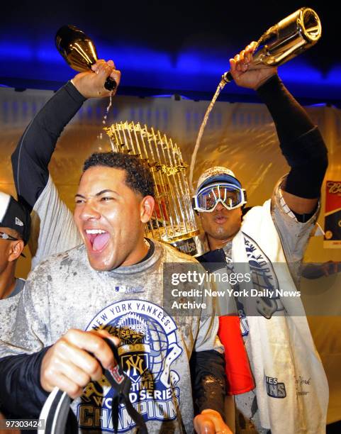 New York Yankees' Melky Cabrera celebrates in clubhouse with Robinson Cano after Yankees win World Series, four games to two, vs. Philadelphia...