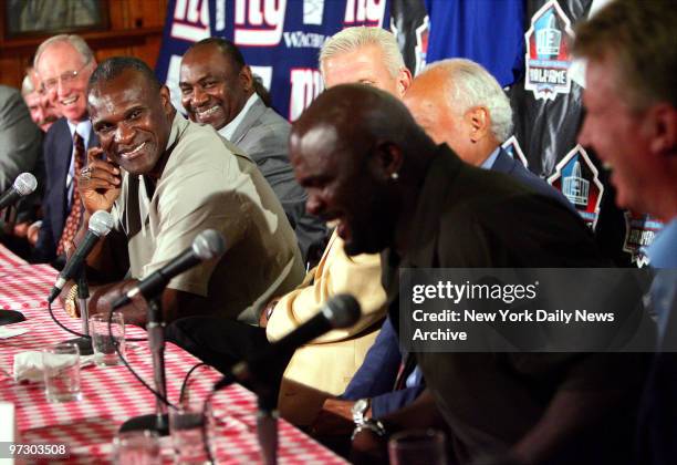 New York Giants' linebacker Harry Carson laughs as former teammate Lawrence Taylor decides he should not finish a story he started during a news...