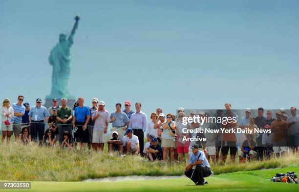 Tiger Woods putts on the second green during first round play at the Barclays Golf Tournament at Liberty National in Jersey City, NJ. Statue of...