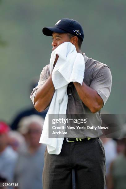 Tiger Woods wipes away the sweat as he feels the heat during first round play in the 87th PGA Championship at Baltusrol Golf Club in Springfield, N.J.