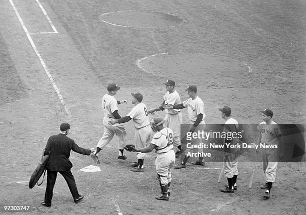 New York Yankees' Mickey Mantle is greeted by Yogi Berra, Hank Bauer, Joe Collins and Billy Martin after belting a grand slam homer in the fifth...