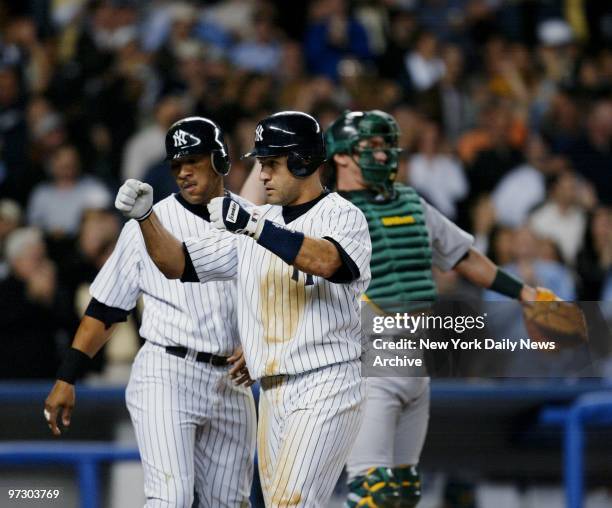 New York Yankees' Miguel Cairo celebrates at home plate with teammate Gary Sheffield after hitting a three-run homer to left field to put the Yanks...