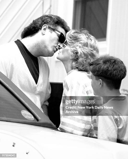 Joey Buttafuock kisses his wife Mary Jo as their son Paul looks on in fornt of the Massapequa home.