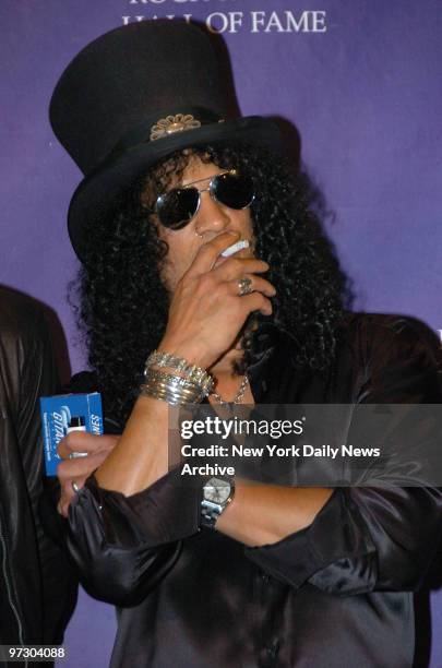 Slash of Velvet Revolver takes a drag from his cigarette while in the press room of the Waldorf Astoria hotel during the 22nd annual Rock and Roll...