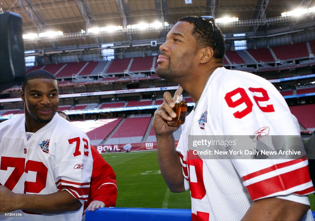 New York Giants' Osi Umenyiora looks on as teammate Michael 