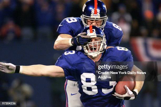 New York Giants' Pete Mitchell and Don Campbell celebrate after Mitchell's catch and run during National Football Conference Division Playoff game...