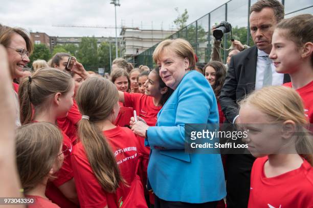 German Chancellor Angela Merkel takes selfies with young girls during a visit of a program to encourage integration of children with foreign roots...