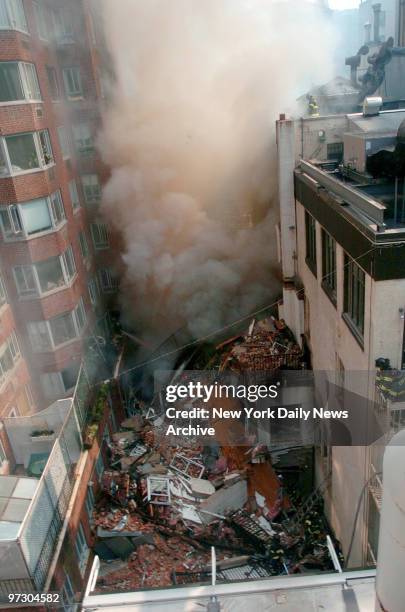 Smoke rises from the remnants of a building at 34 E. 62nd St., which was reduced to rubble by a natural gas explosion this morning. The owner of the...