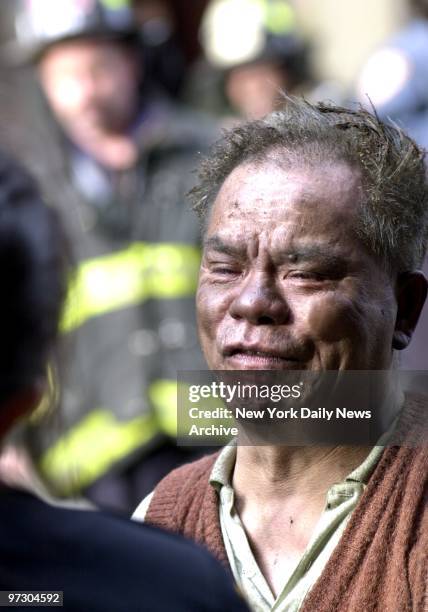Smoke stained father, Kam Gin Chiu, 59 years old, weeps as his children, Amy, 1 year old and, Anthony, 5 years old are pulled from burning tenement...