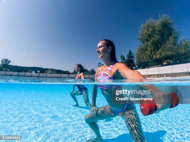 frauen, die das training mit hanteln im schwimmbad - aquarobics stock-fotos und bilder