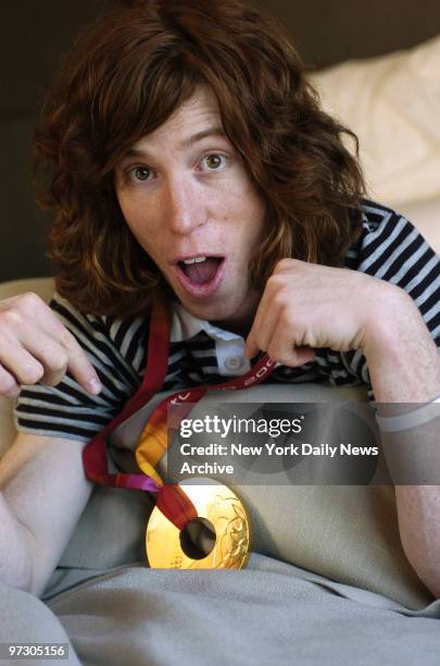 Snowboarder Shaun White shows off his gold medal at the SoHo Grand Hotel after returning from the 2006 Winter Olympic Games in Turin, Italy, where he...