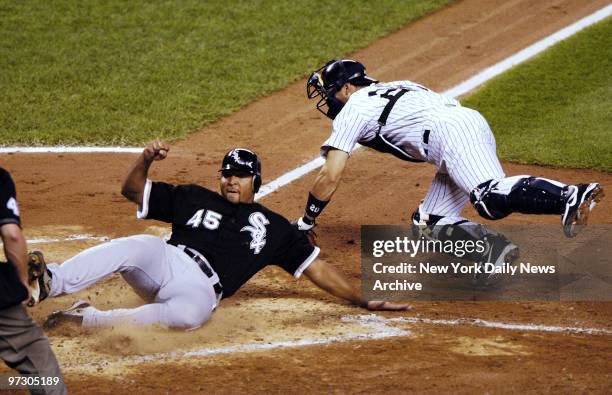 Chicago White Sox' Carlos Lee beats the throw home as he slides past New York Yankees' catcher Jorge Posada to score in the fourth inning at Yankee...