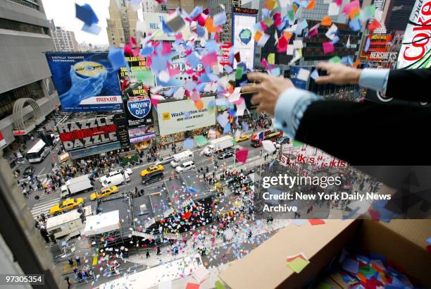 Tim Tompkins of the Times Square Alliance throws confetti out of a window at 46th and Broadway during the annual confetti flight test in preparation...