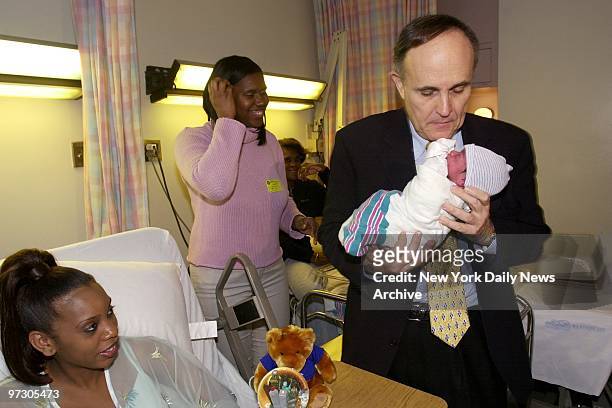 Maurica Robinson watches from her bed as Mayor Rudy Giuliani cuddles her newborn son, Peter Ashfield 3rd, at SUNY Downstate Hospital in Brooklyn....